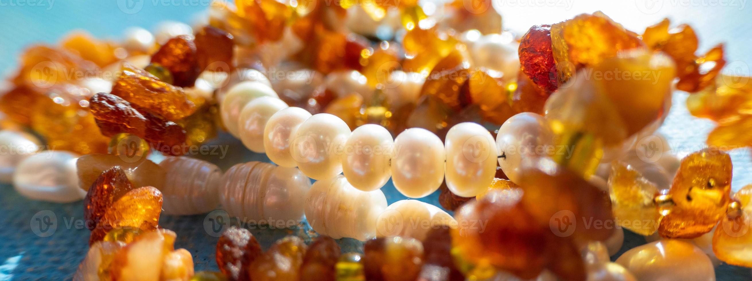 soleggiato perline di ambra perla lapis lazuli su blu sfondo. naturale mare pietra preziosa luce del sole sfondo, gioielleria concetto foto