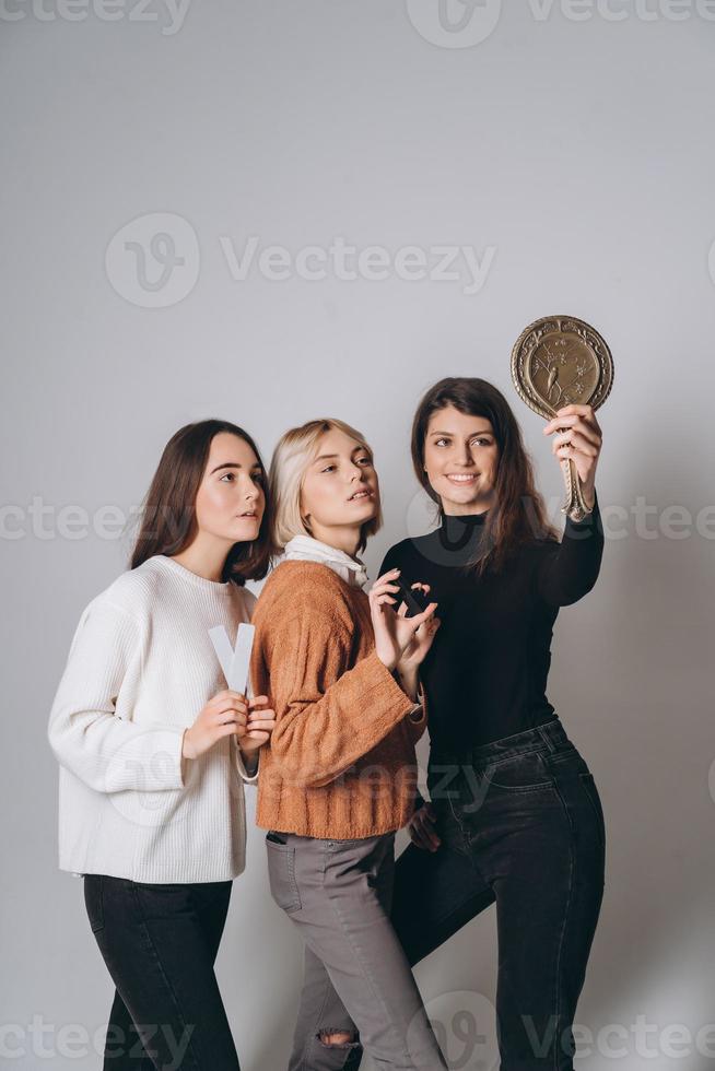 tre bellissimo giovane ragazze in posa per il telecamera foto