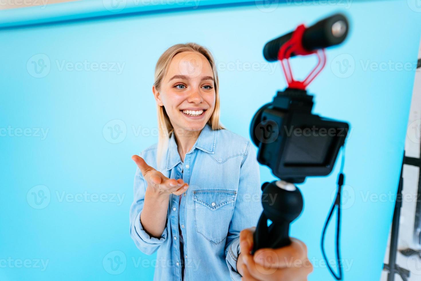 bellissimo ragazza blogger allevia si a telecamera isolato blu sfondo foto