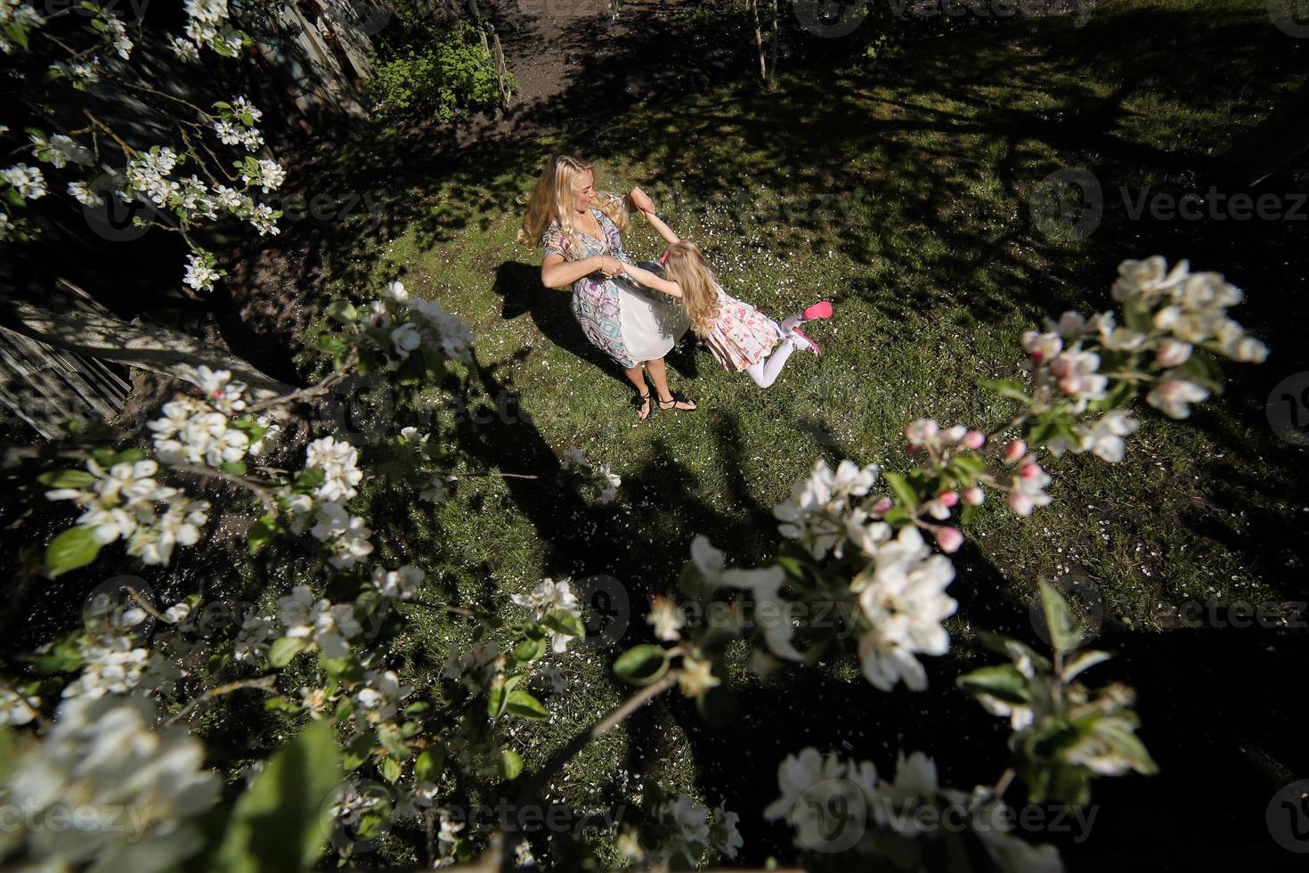 madre torcere figlia nel il giardino foto