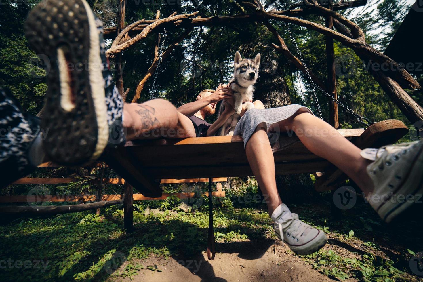 bellissimo coppia insieme con cane su un' swing foto