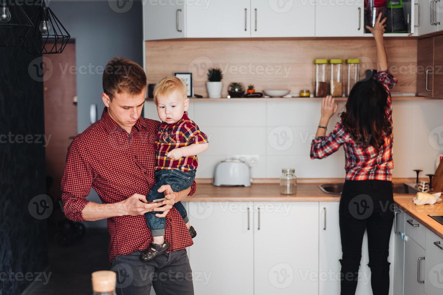 papà, mamma e poco figlio nel il cucina foto