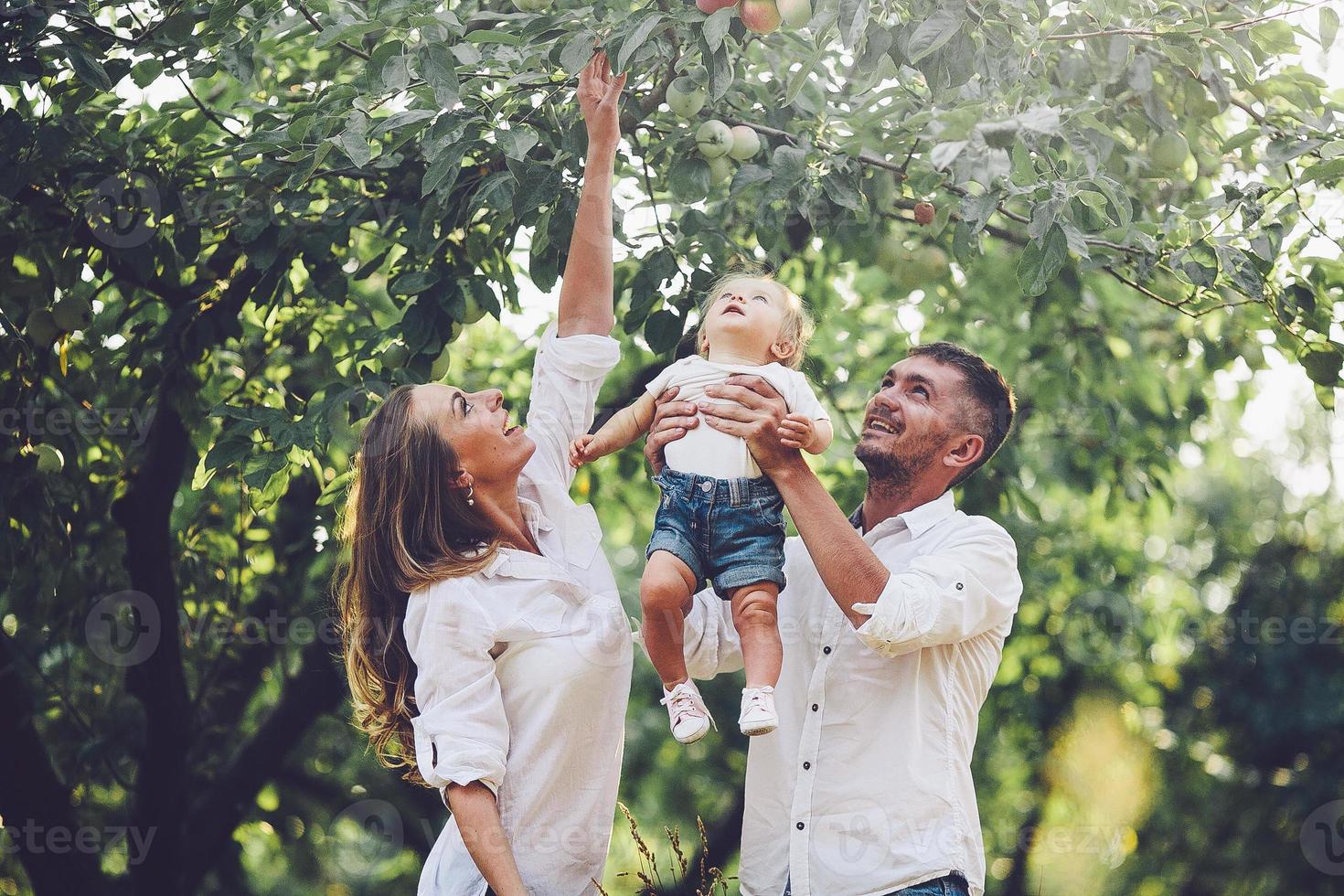 famiglie con un' bambino nel il estate giardino foto