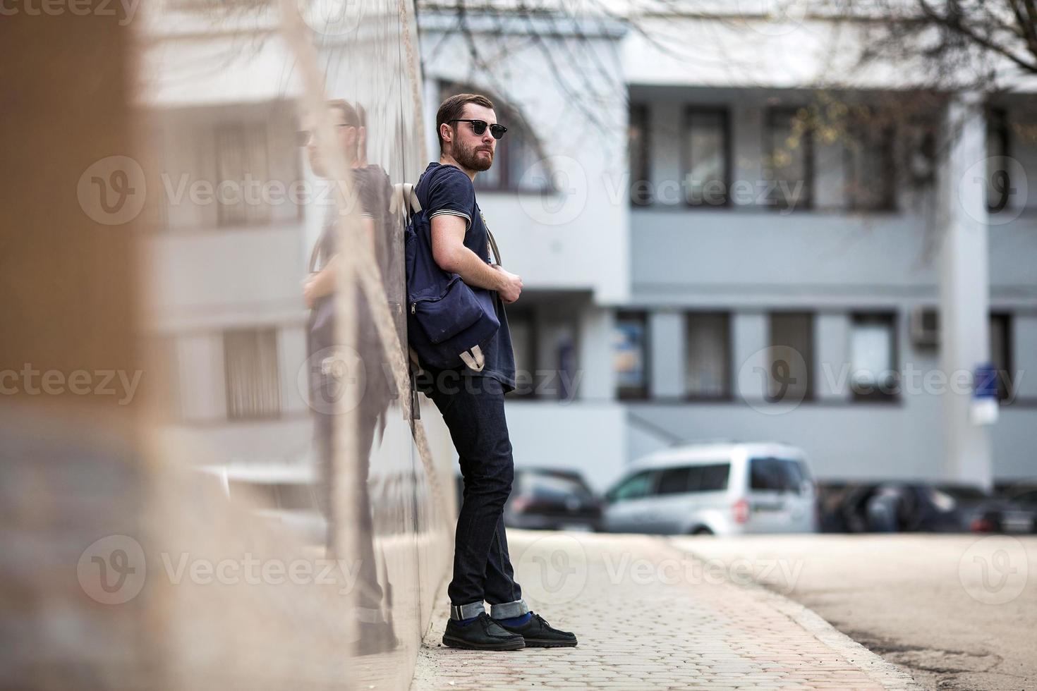 l'uomo con gli stivali autentici e i jeans a cimosa sullo sfondo della città vecchia foto