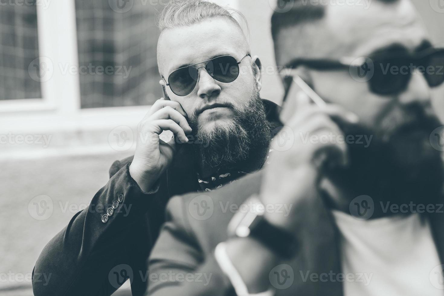 due uomo d'affari barbuto guardando il telefono foto