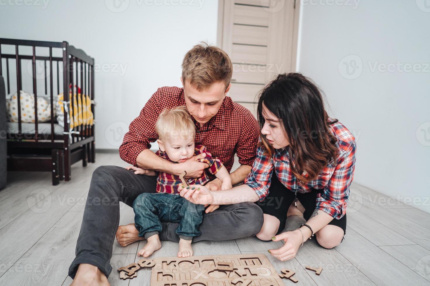 contento famiglia siamo giocando insieme su il pavimento foto