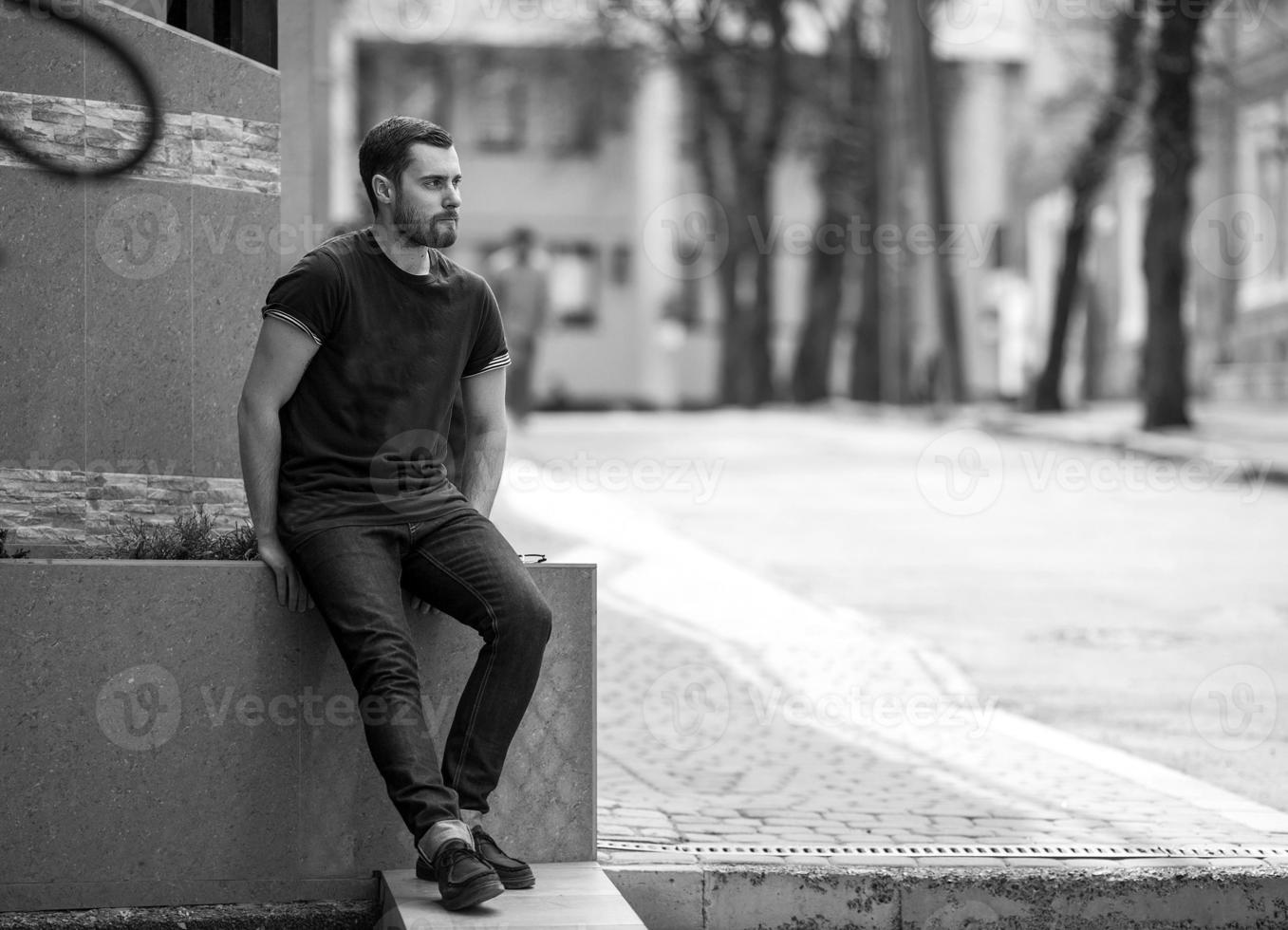 l'uomo con gli stivali autentici e i jeans a cimosa sullo sfondo della città vecchia foto