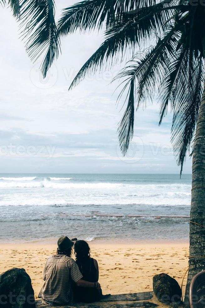 coppia seduta sotto palma alberi foto