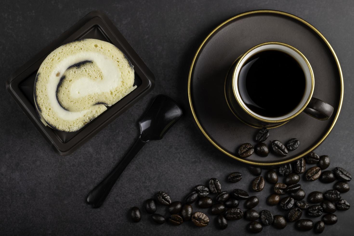 caffè nel Marrone tazza con torta Là era un' nero cucchiaio e un' pochi caffè fagioli per il scena. foto