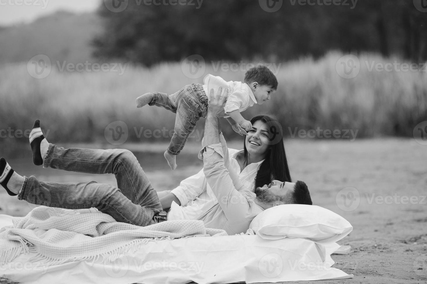 contento giovane famiglia rilassante insieme su il lago foto