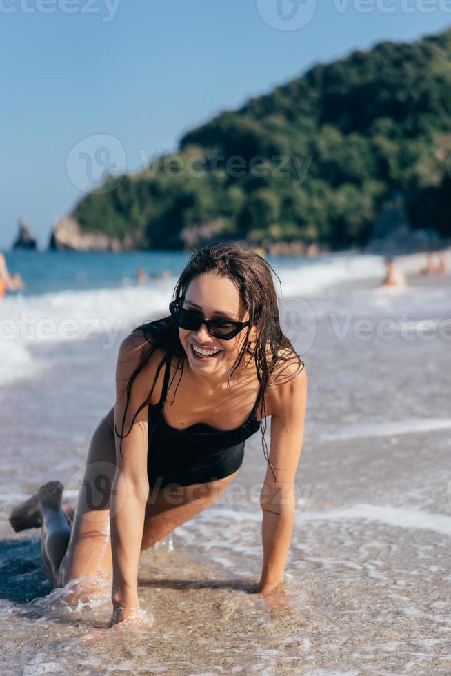 sexy giovane brunetta in posa su sua ginocchia nel il mare foto