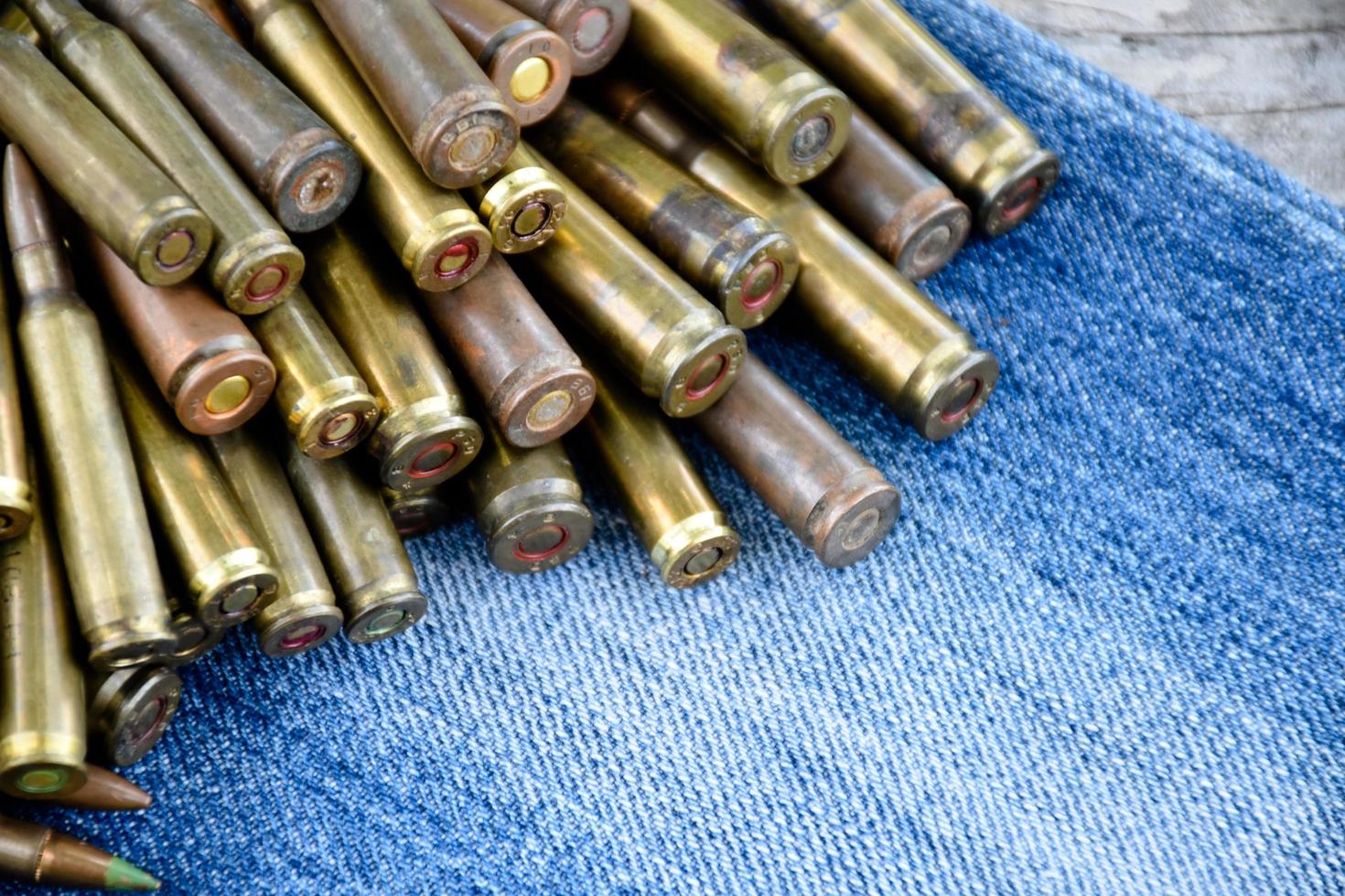 avvicinamento Visualizza di il vecchio proiettili su jeans pavimento, morbido e selettivo messa a fuoco su proiettili, concetto per raccolta vecchio proiettili nel gratuito volte. foto