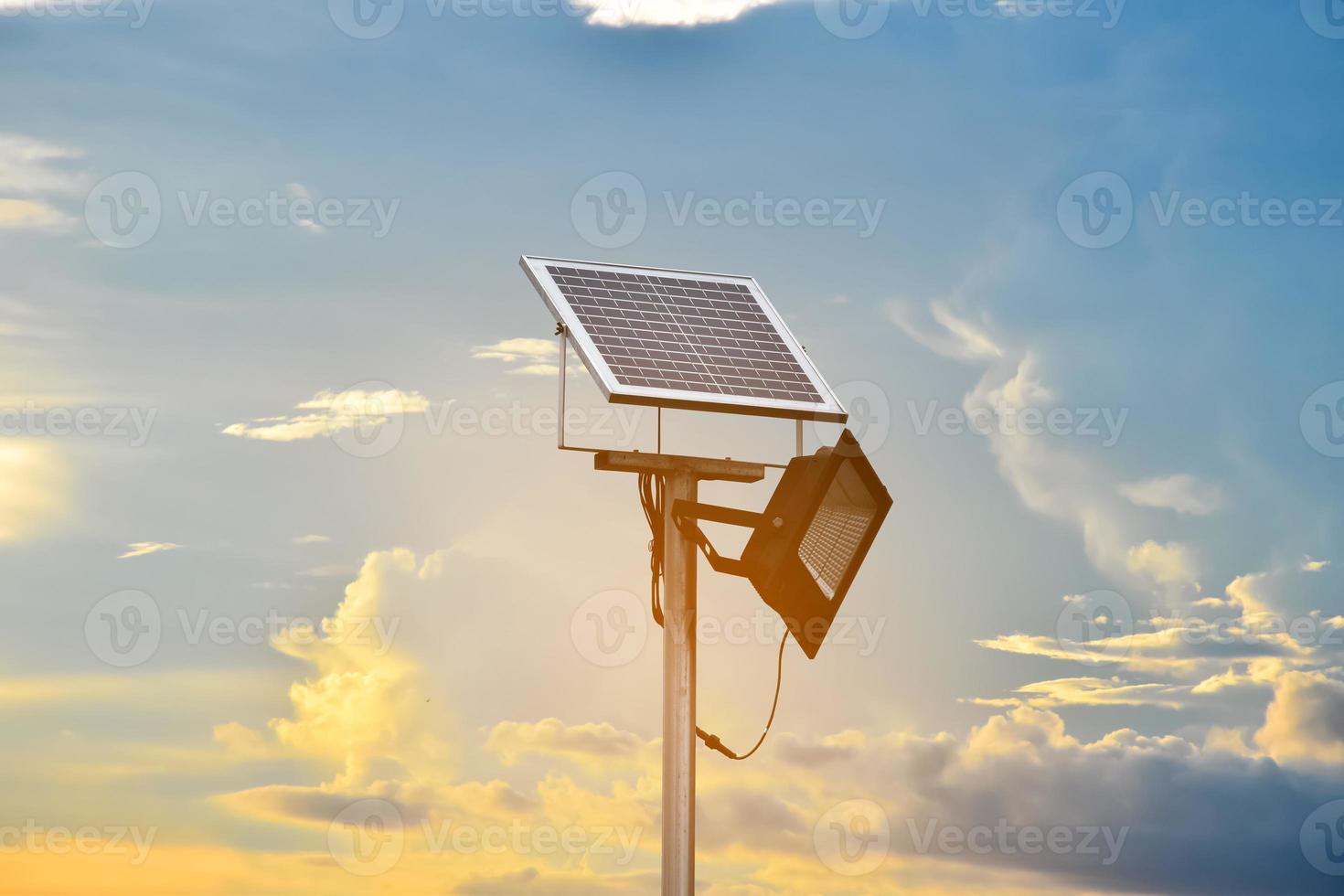 mini solare o fotovoltaico cellula pannello installato su metallo polo con proiettore portato, sfocatura nuvoloso e cielo blu sfondo, concetto per utilizzando naturale energia a partire dal il sole nel quotidiano vita di umano. foto