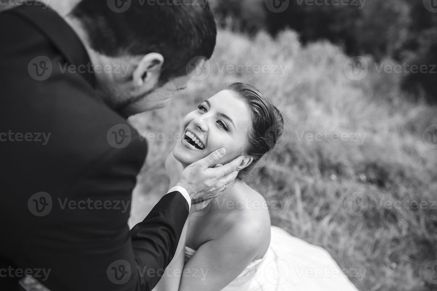 sposo delicatamente tocchi il viso di il suo sposa foto