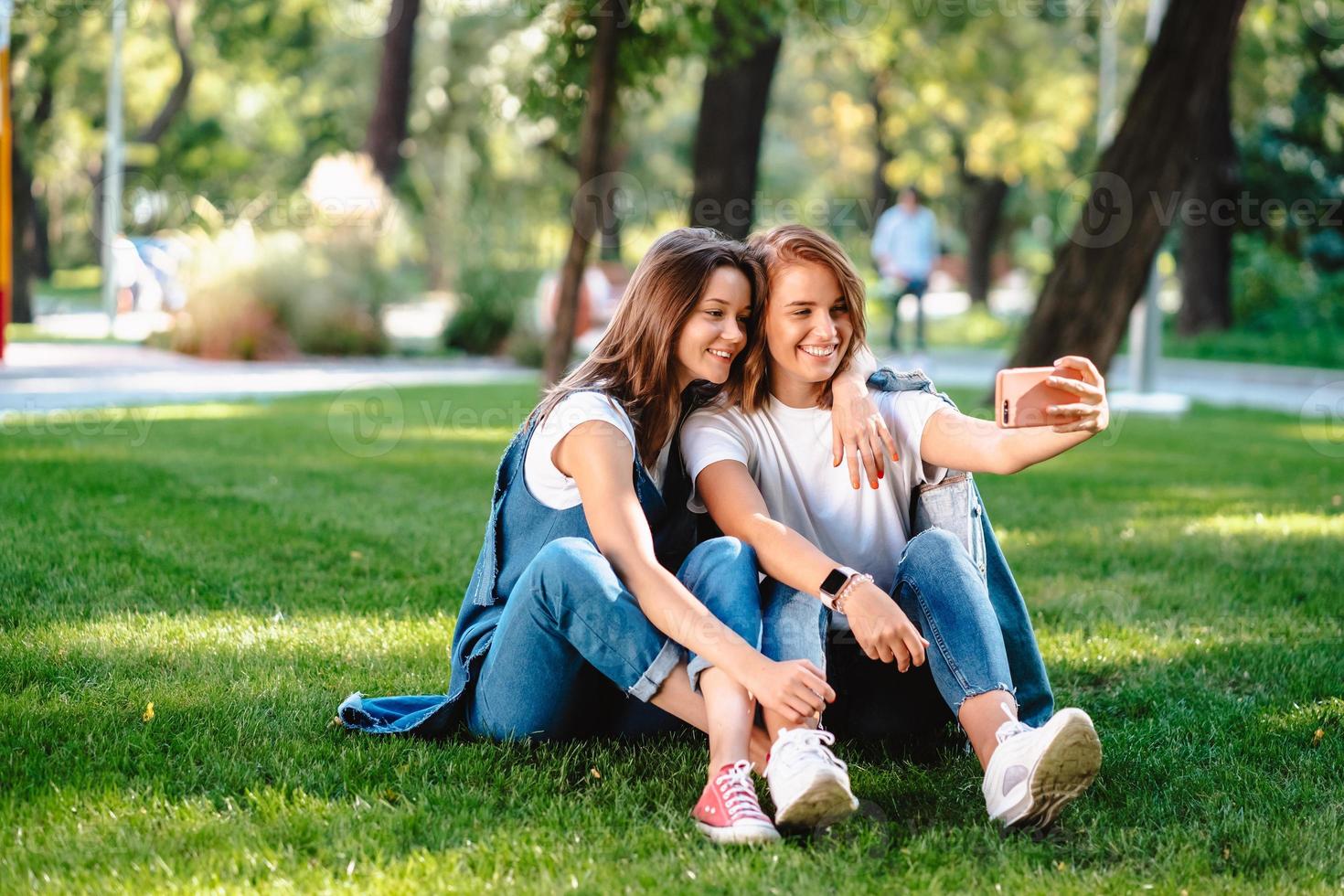 Due femmina amico seduta nel il parco avere un' riposo prendere un' autoscatto foto