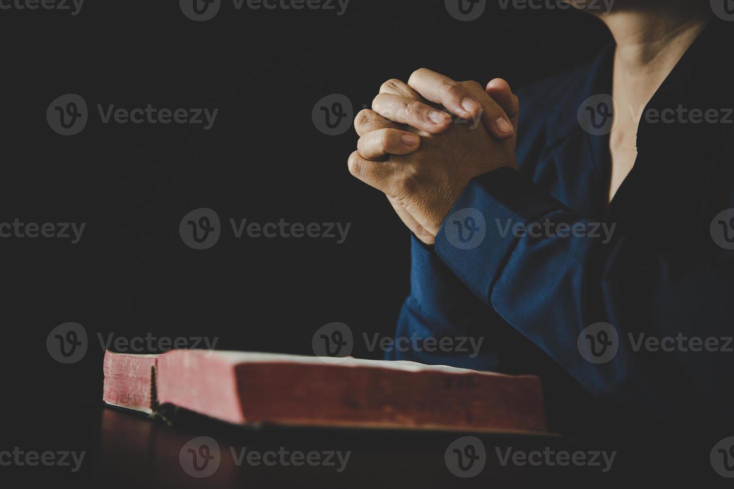 mano piegato nel preghiera per Dio su santo Bibbia libro nel Chiesa concetto per fede, spiritualità e religione, donna persona preghiere su santo Bibbia nel mattina. cristiano cattolico donna mano con Bibbia culto. foto
