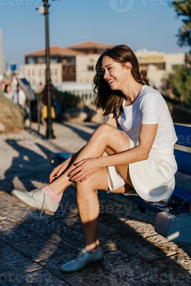 giovane donna legatura sua scarpe nel il parco foto