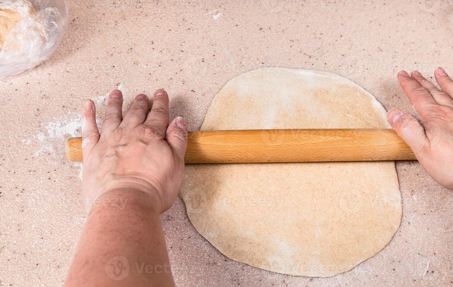 mani appiattire foglio di Impasto di di legno rotolamento perno foto