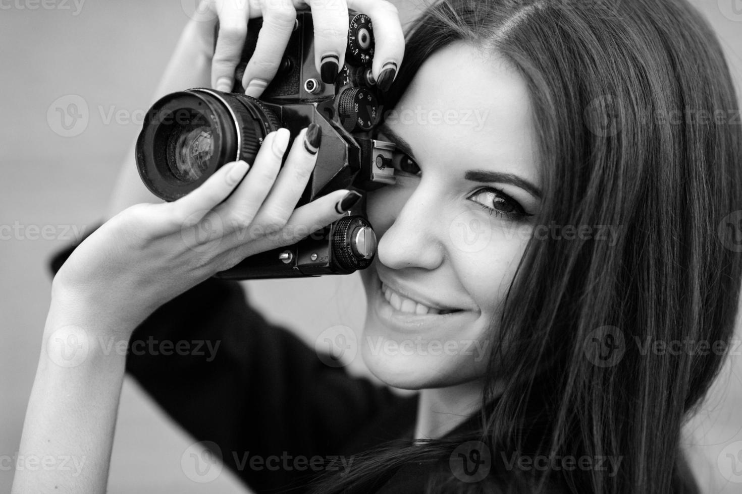 bellissimo femmina fotografo in posa con telecamera foto