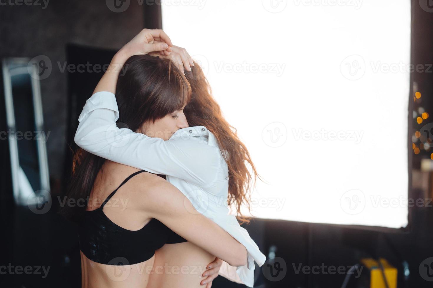 Due ragazze nel ogni altri tenero abbraccia foto