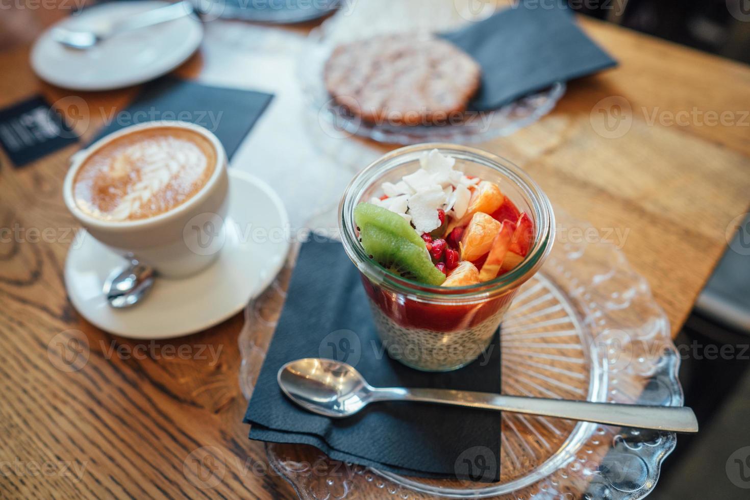 cappuccino con cucchiaio nel tazza e dolce foto