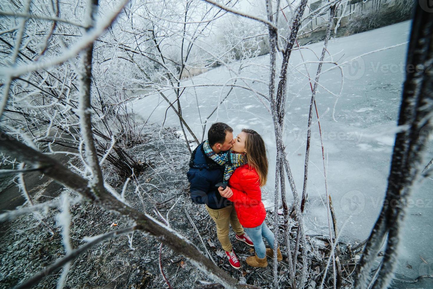 bellissimo coppia in posa vicino un' congelato fiume foto