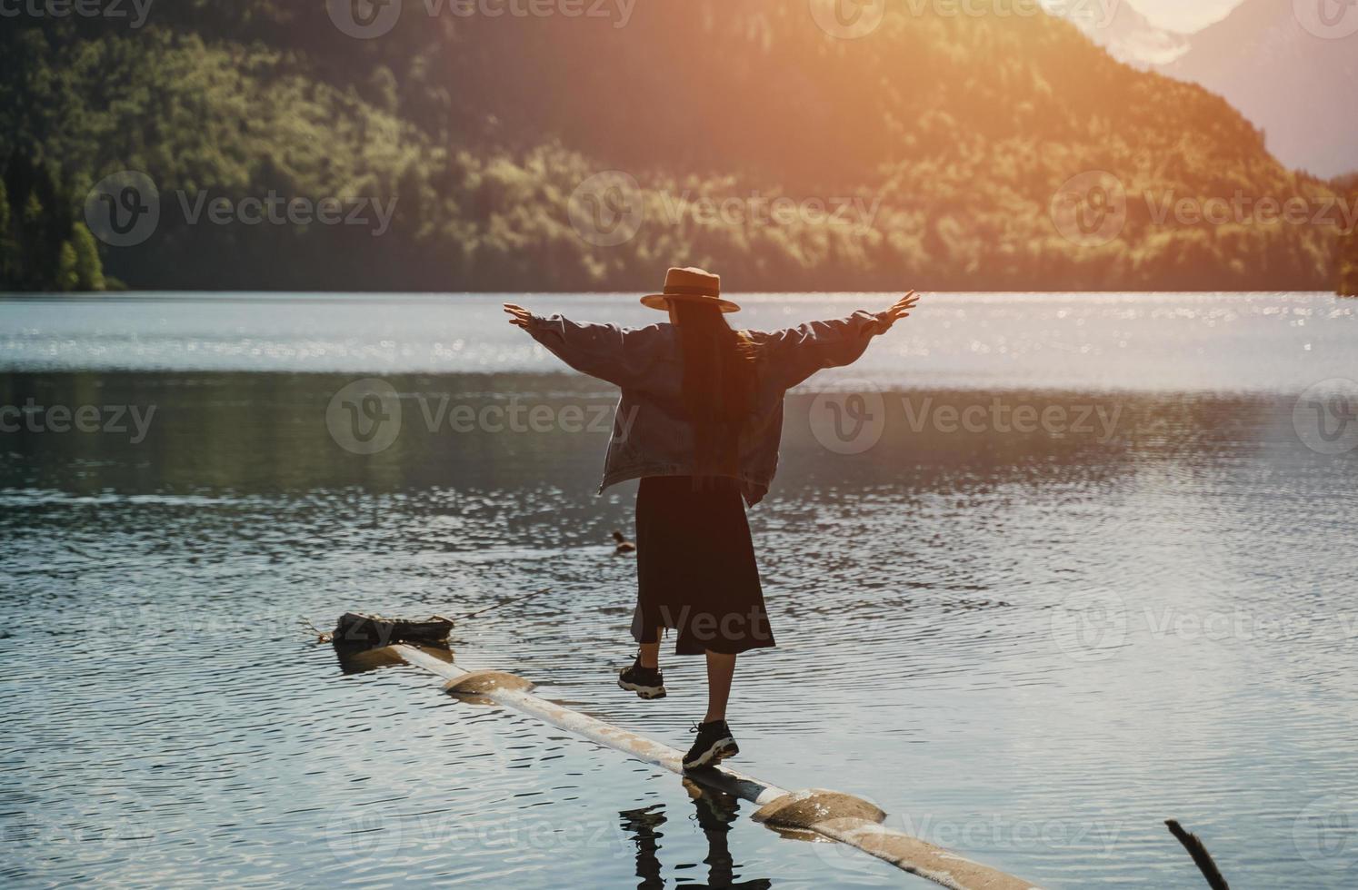 il ragazza nel il vestito e cappello di il lago nel il montagne foto