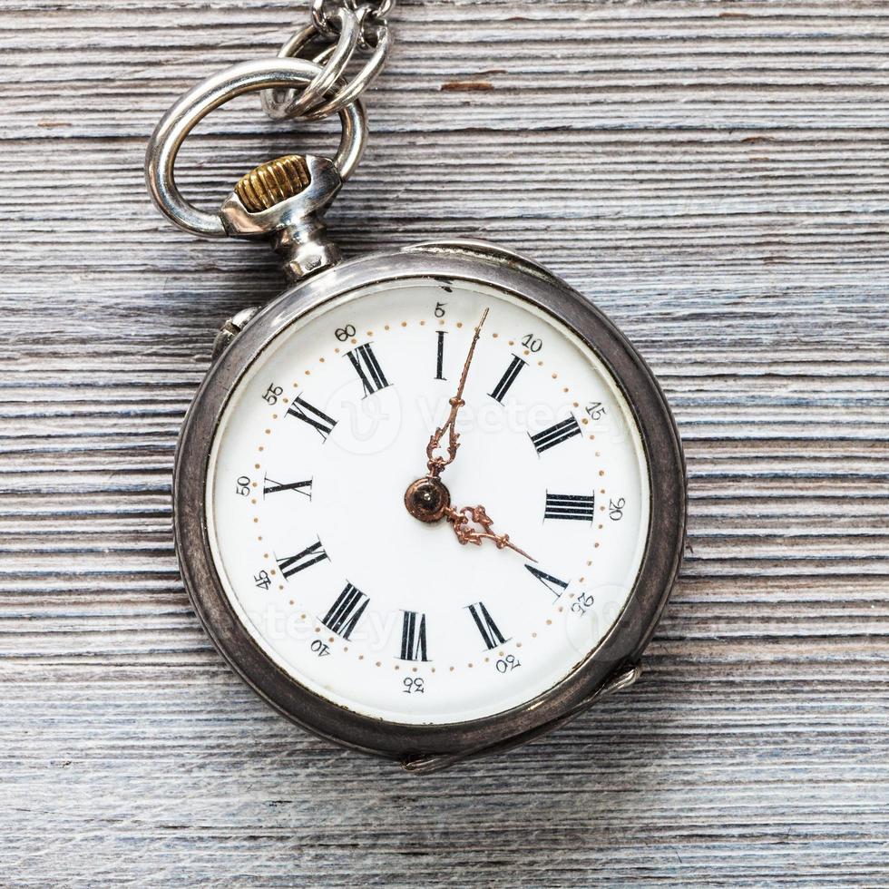 vecchio tasca orologio su grigio di legno tavolo foto