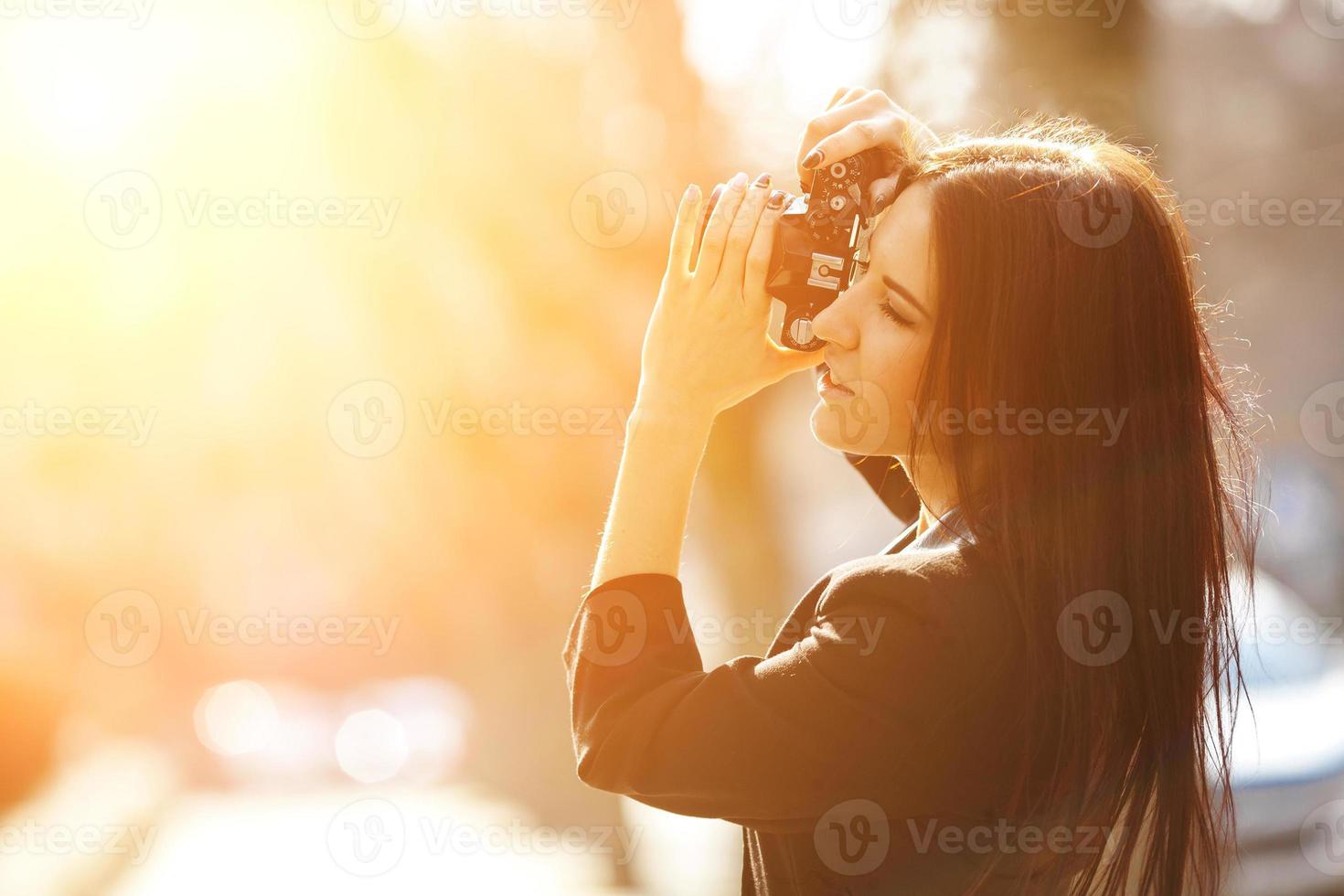 bellissimo femmina fotografo in posa con telecamera foto