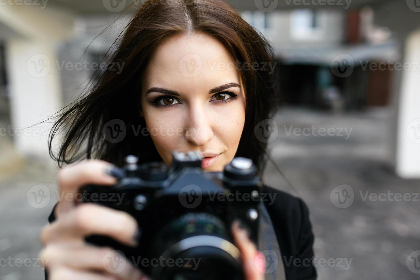 bellissimo femmina fotografo in posa con telecamera foto