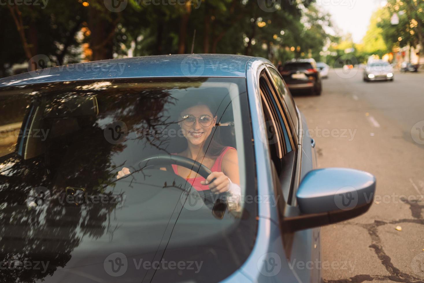bellissimo sorridente donna guida macchina, ragazza seduta nel automobile foto