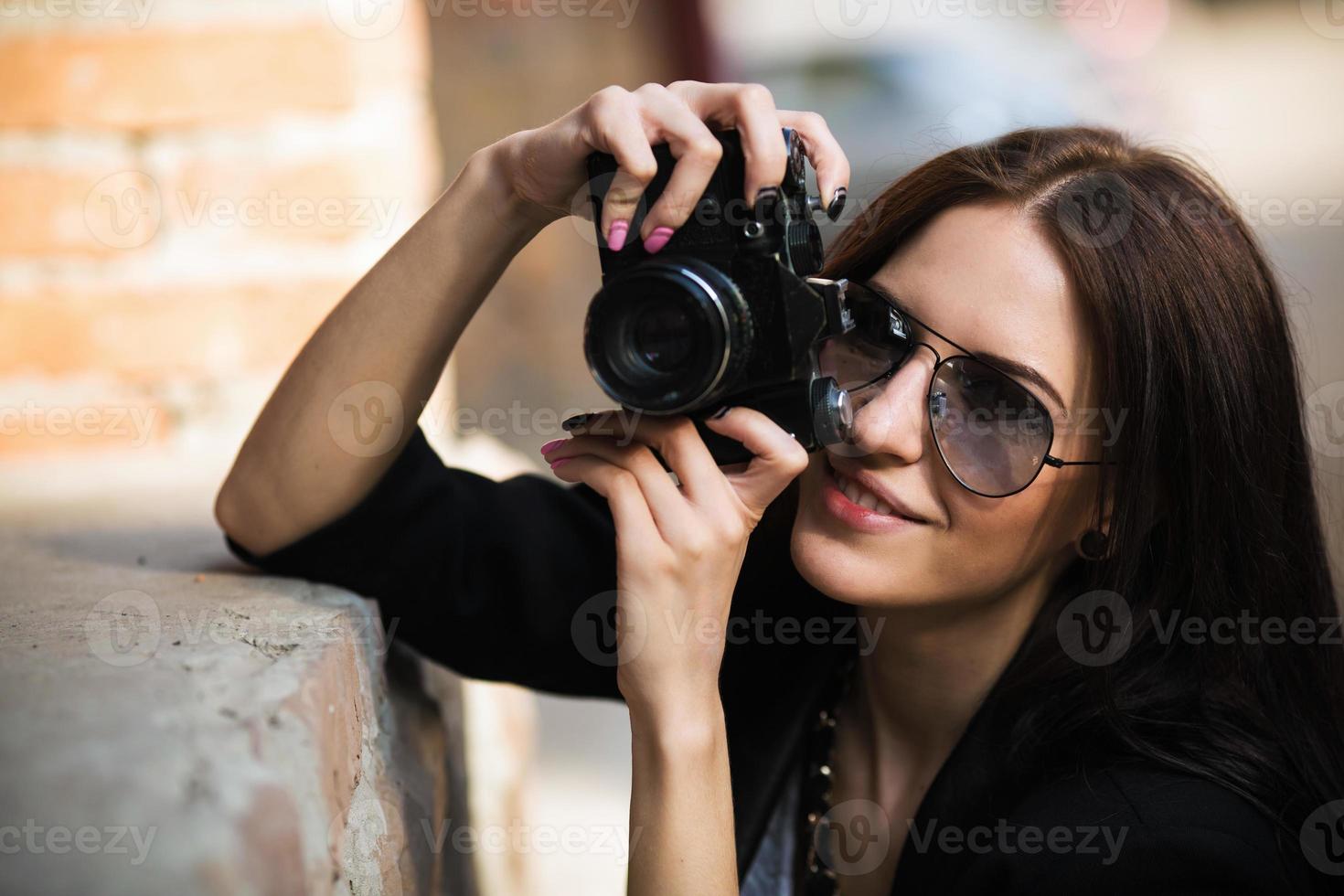 bellissimo femmina fotografo in posa con telecamera foto