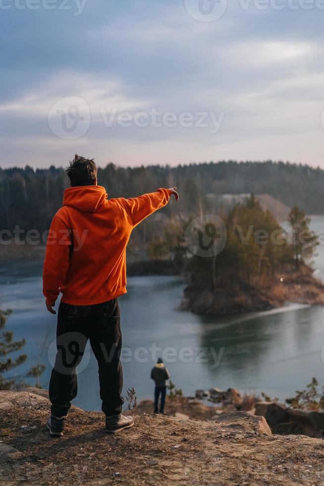 un' giovane uomo in piedi su il bordo di un' scogliera pose per il telecamera foto