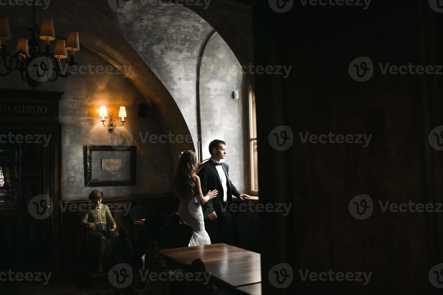 il sposa e sposo nel un' accogliente Casa, foto prese con naturale leggero a partire dal il finestra.