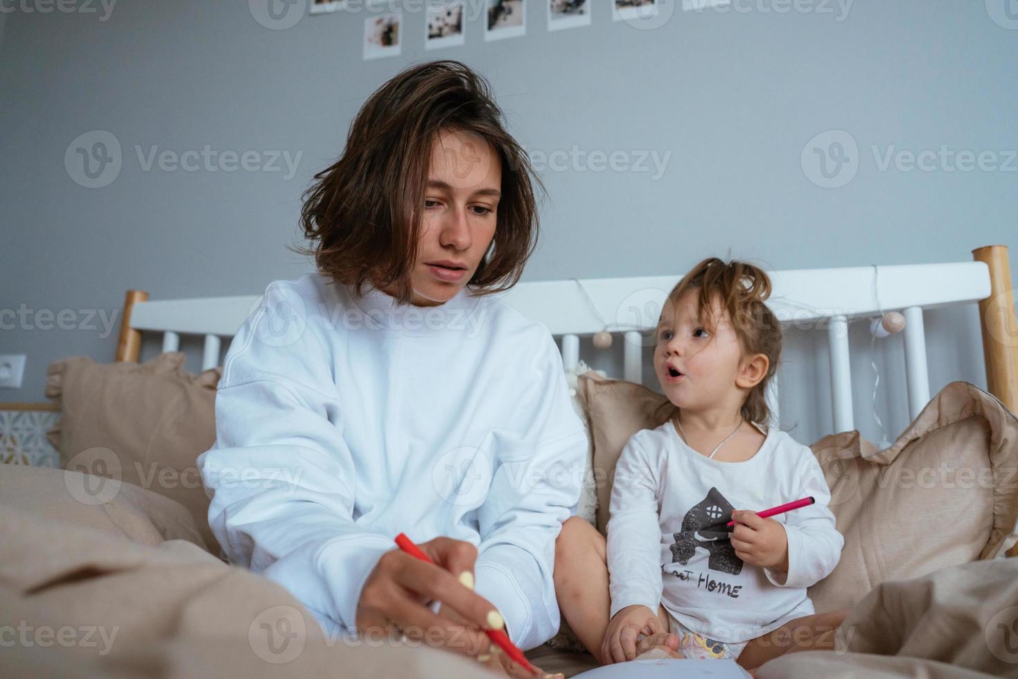 mamma e figlia disegnare nel letto foto