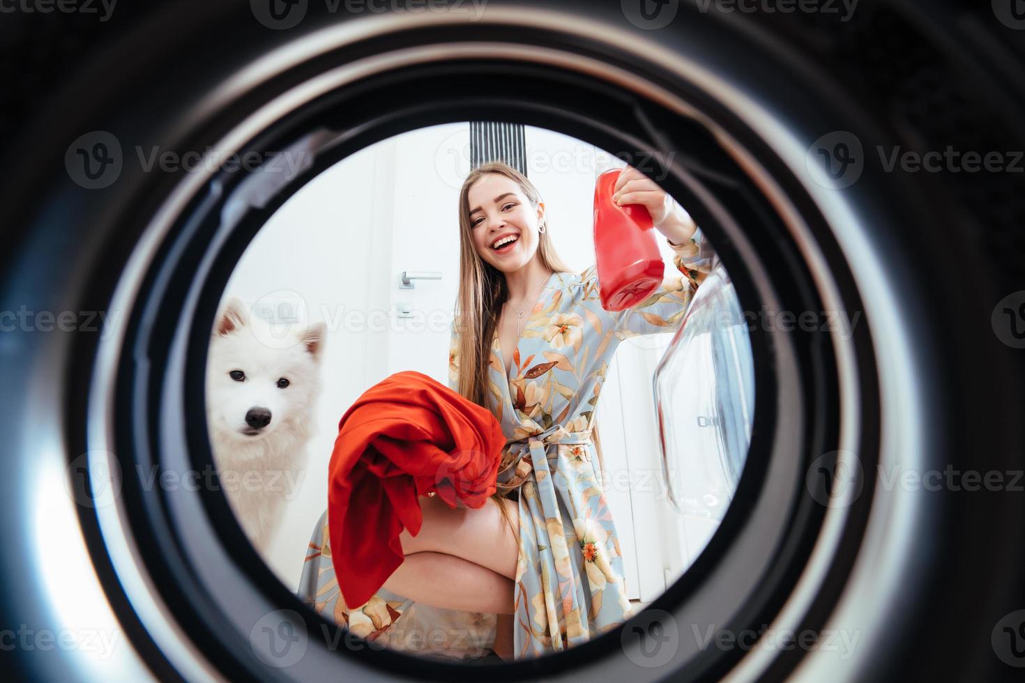 giovane donna a casa mette il vestito nel il essiccazione macchina. foto