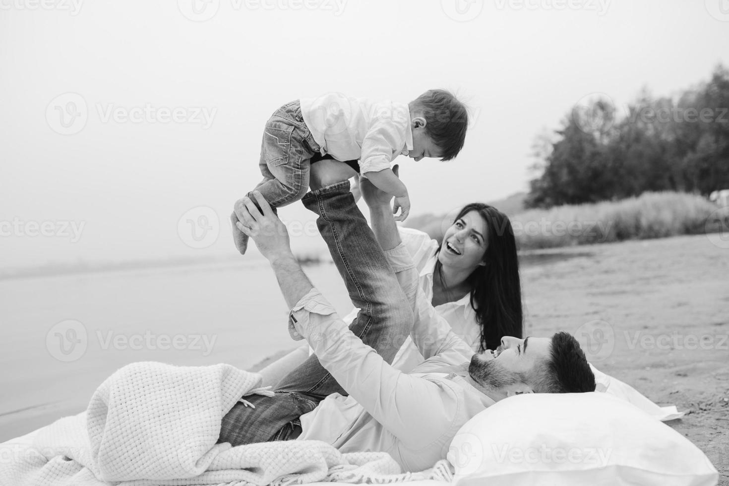 contento giovane famiglia rilassante insieme su il lago foto