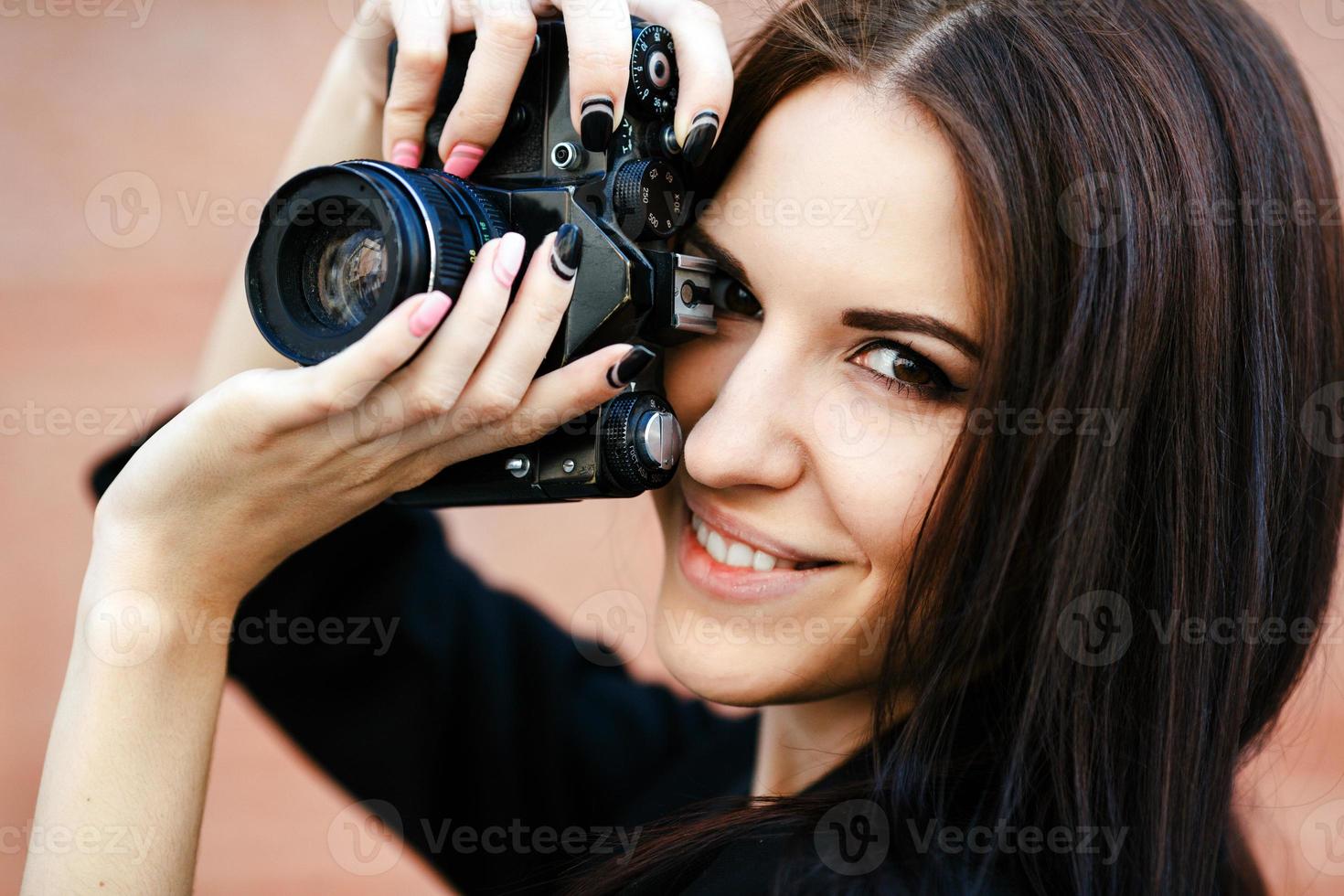 bellissimo femmina fotografo in posa con telecamera foto