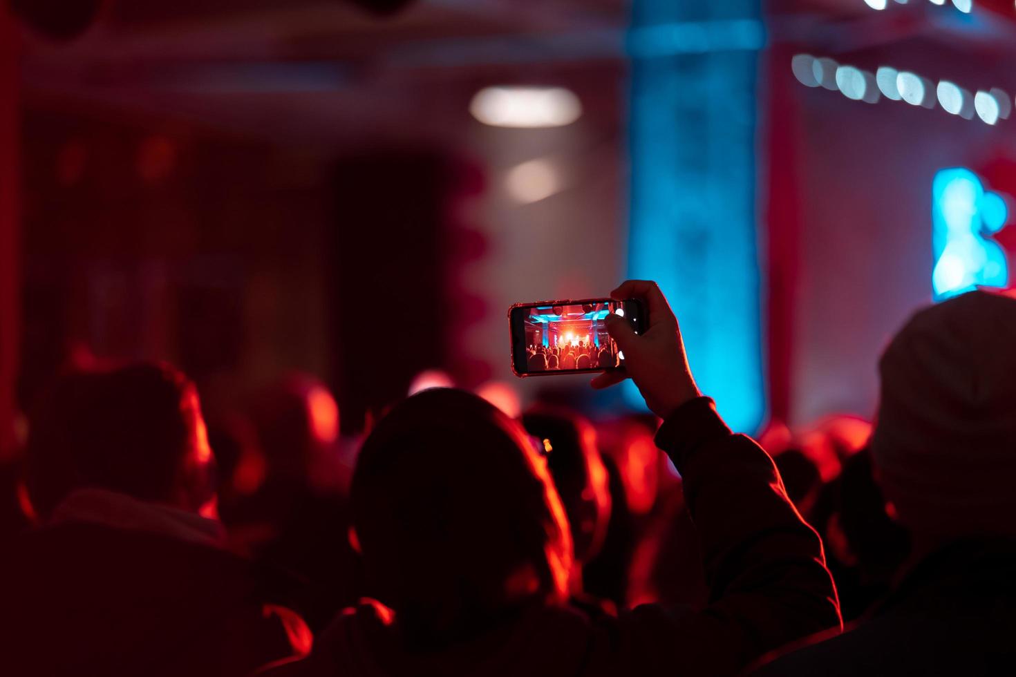 persona vicino su di registrazione video con smartphone durante un' concerto. foto