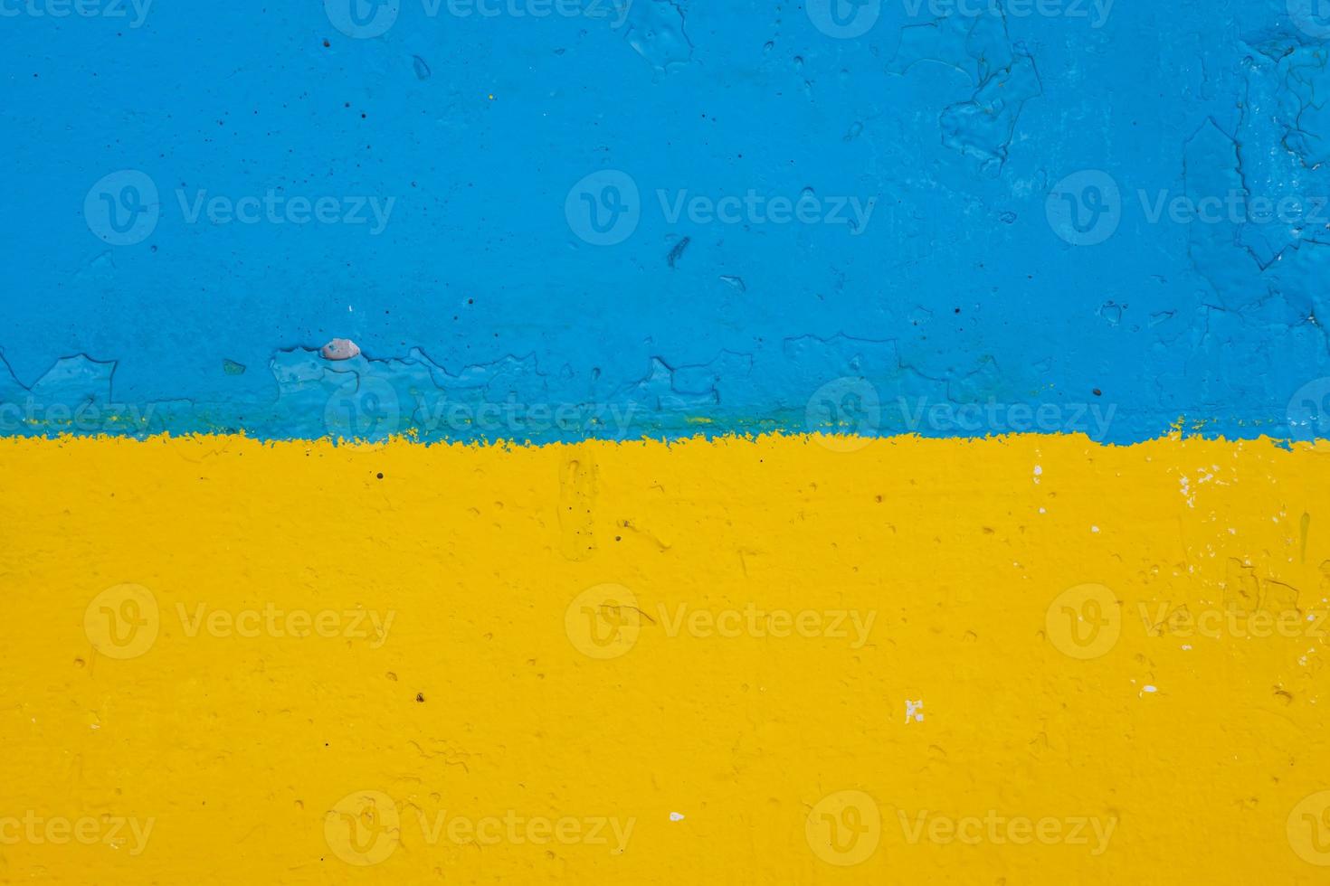 calcestruzzo parete dipinto nel giallo e blu piace ucraino bandiera, il nazione di vittima di il aggressore foto