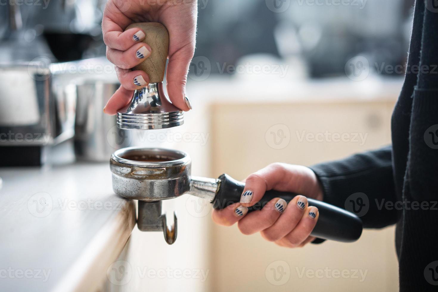 barista presse terra caffè utilizzando manomettere. foto