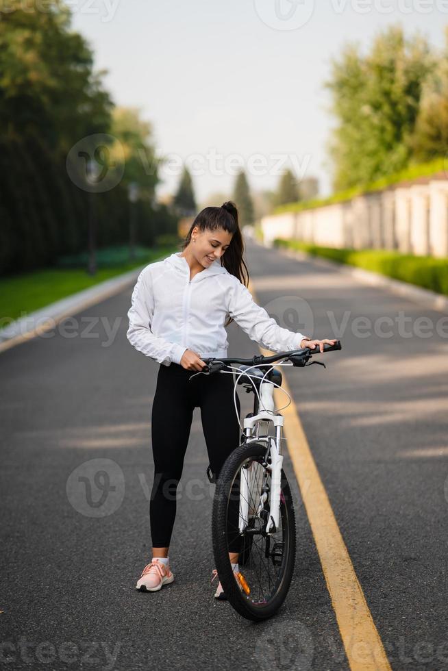 bellissimo ragazza in posa a bianca bicicletta. camminare nel natura. foto