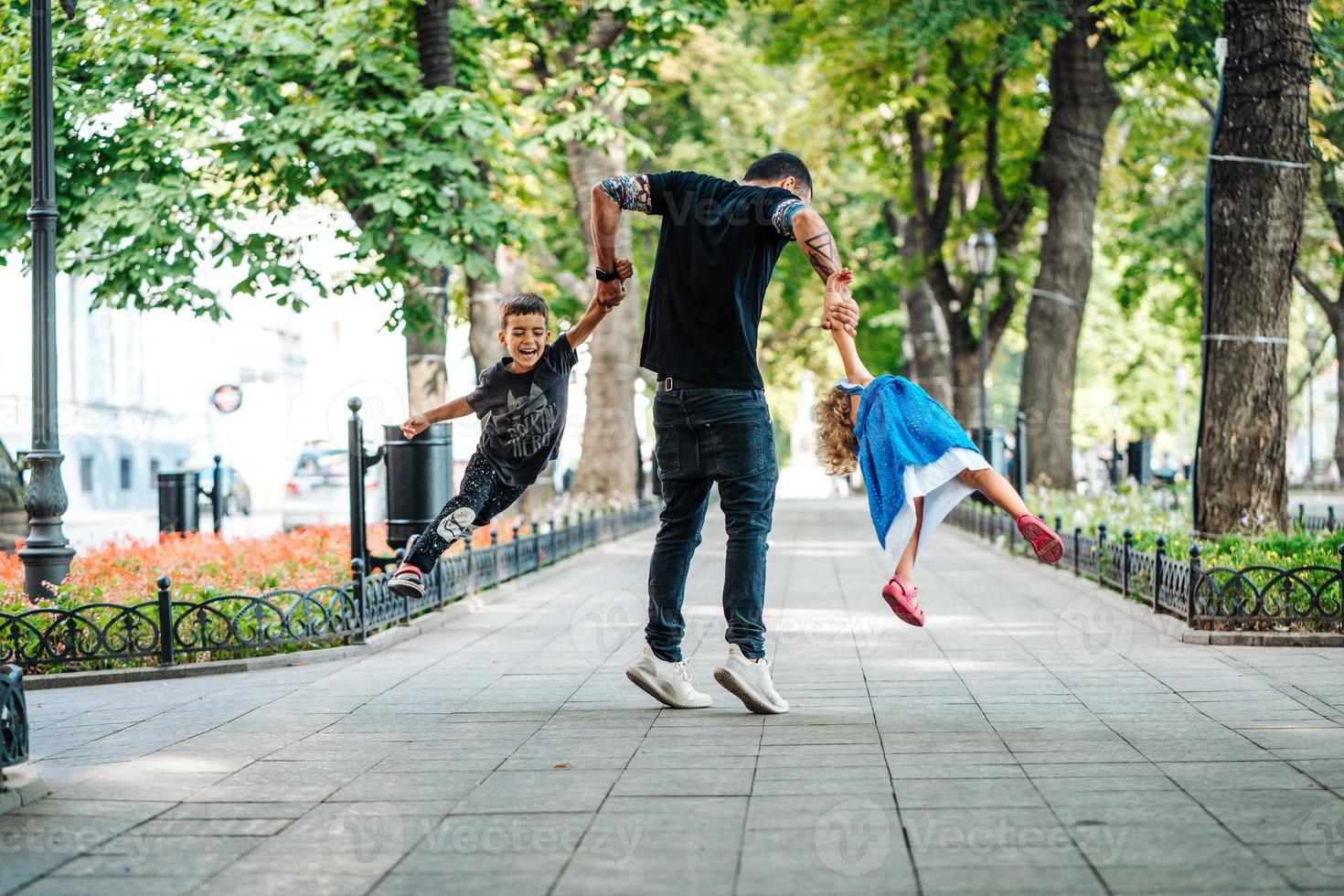 bambini avendo divertimento con papà nel il parco foto