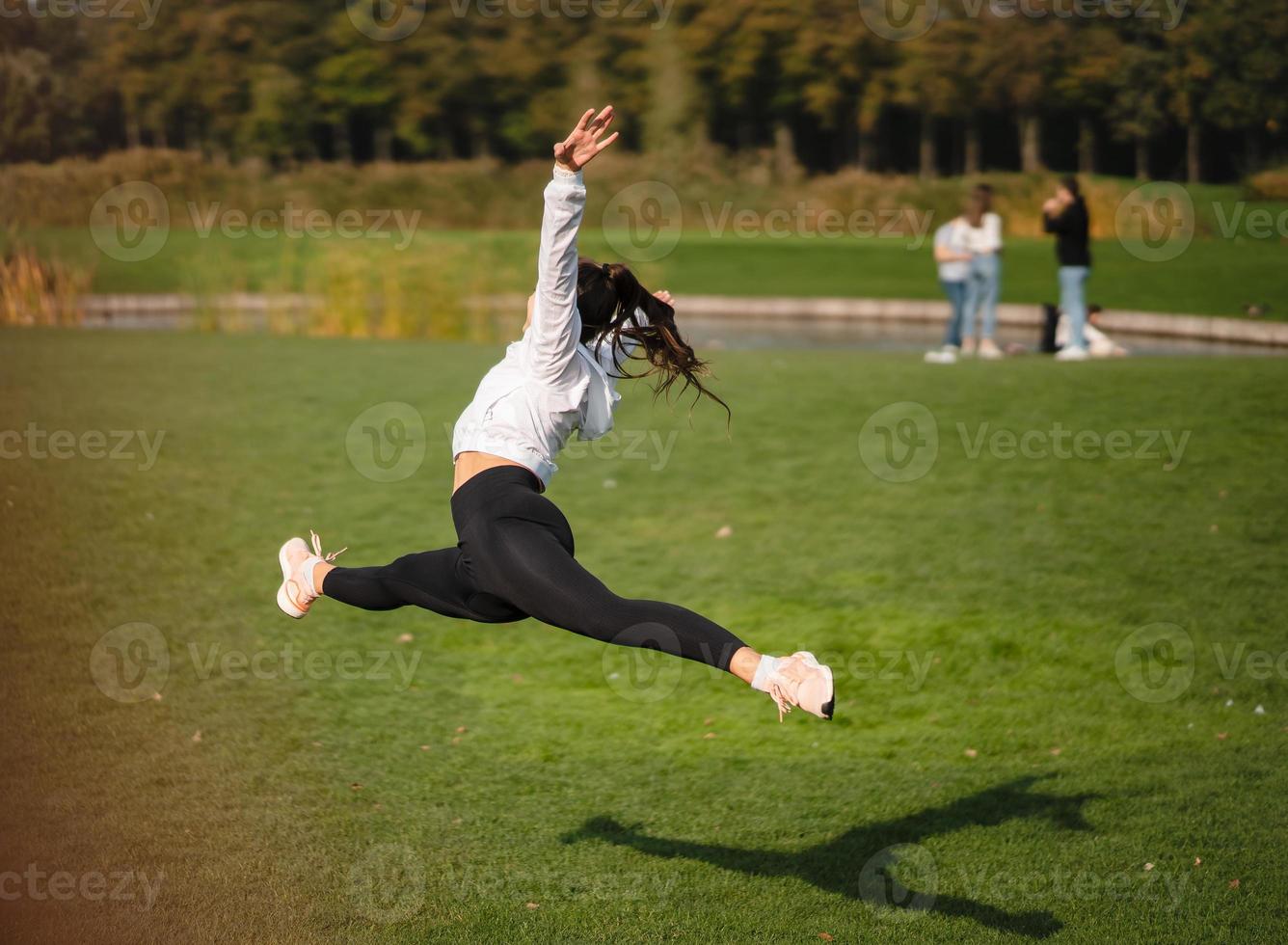 sport ragazza salto nel il aria su natura dimostrare Perfetto allungamento. foto