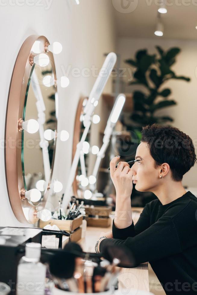 attraente donna a il specchio nel bellezza studio foto