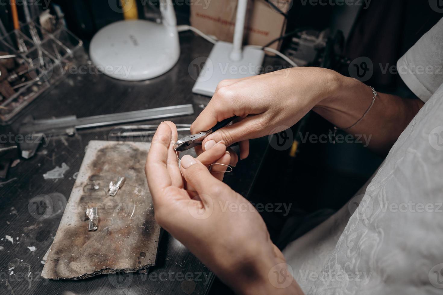 donna gioielliere tagli via un' pezzo di saldare con tronchesino foto
