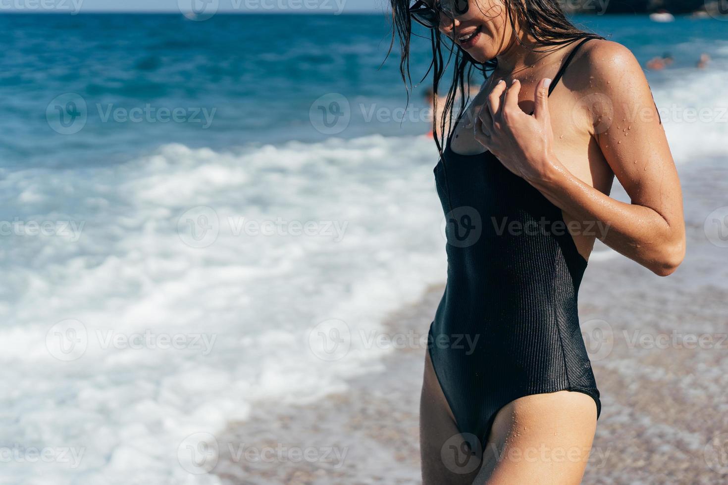 bellissimo giovane donna nel nero bagnato costume da bagno foto