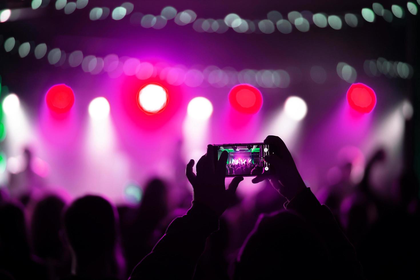 persona vicino su di registrazione video con smartphone durante un' concerto. foto