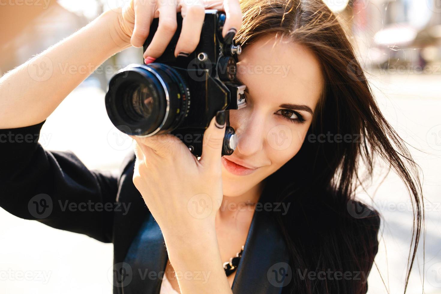 bellissimo femmina fotografo in posa con telecamera foto