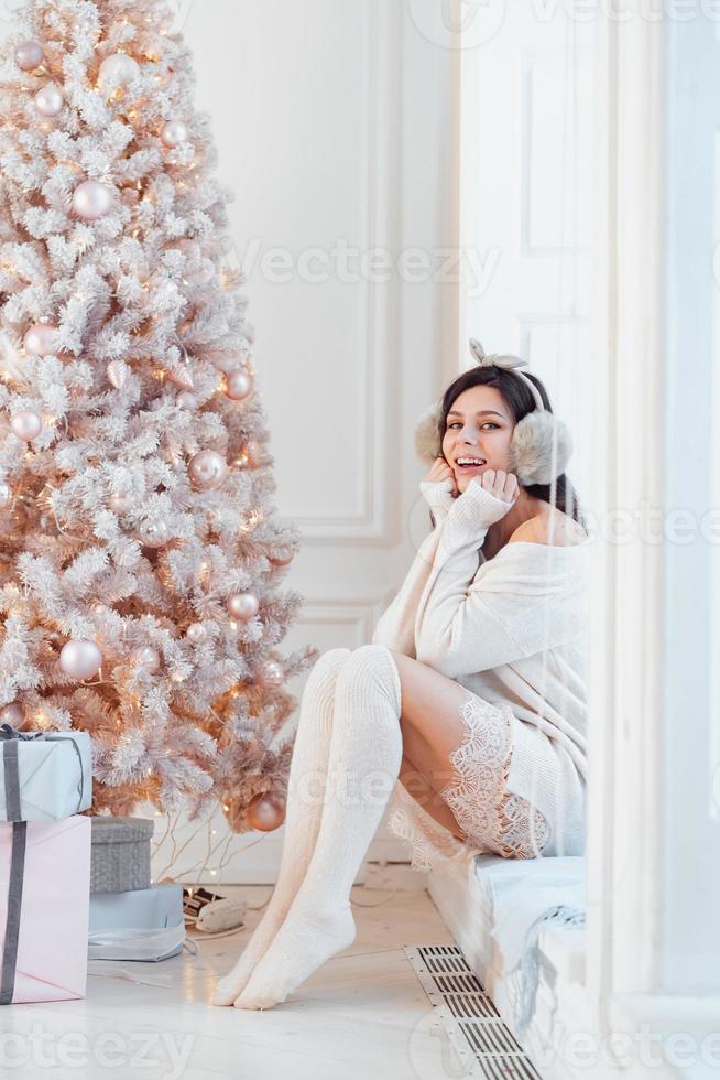 giovane donna nel un elegante vestito vicino il Natale albero foto